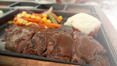 Restoran masasında servis edilen biftek, pirinç ve sebzeleri yakından izleyin.