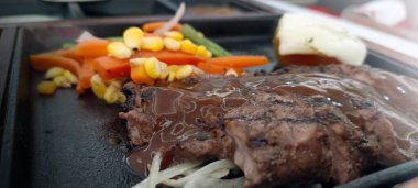 Restoran masasında servis edilen biftek, pirinç ve sebzeleri yakından izleyin.