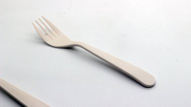 Beyaz arka planda izole edilmiş beyaz plastik kaşık ve çatal