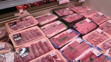 Endonezya süpermarketinde fiyat etiketleriyle sarılmış taze et.