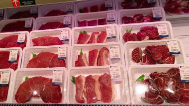 Endonezya süpermarketinde fiyat etiketleriyle sarılmış taze et.