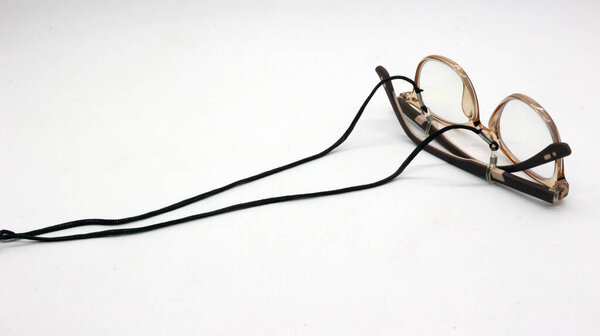Коричневые очки с черным ремешком для очков на белом фоне.