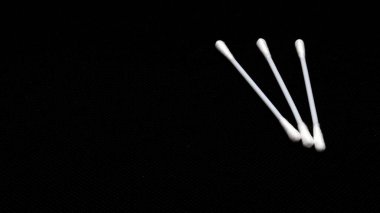 Siyah arka planda izole edilmiş kulakları temizlemek için pamuk çubukları