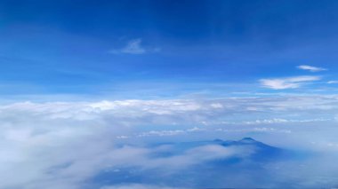 Uçak penceresinden bulutların ve dağların görüntüsü