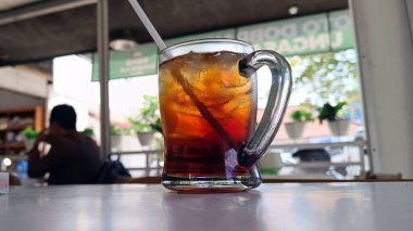 Lokanta masasında samanla birlikte buzlu çay.