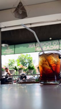 Lokanta masasında samanla birlikte buzlu çay.