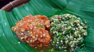 Kırmızı biber sosu ve yeşil biber sosu, muz yaprakları üzerinde servis edilir..