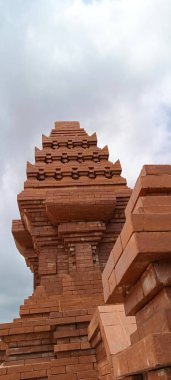 Kırmızı tuğladan yapılmış, Balili ya da tapınak tasarımlı bir kapı..