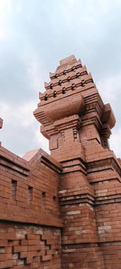 Kırmızı tuğladan yapılmış, Balili ya da tapınak tasarımlı bir kapı..