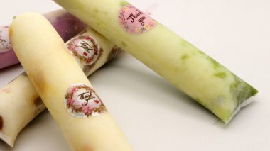 Beyaz arka planda izole edilmiş plastiğe sarılı pop buz çubuğu