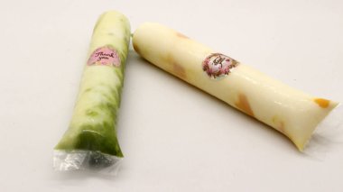 Beyaz arka planda izole edilmiş plastiğe sarılı pop buz çubuğu