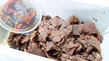 Pişmiş ve paketlenmiş et parçaları, servis edilmeye ve yenmeye hazır.