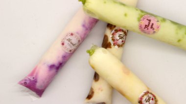 Beyaz arka planda izole edilmiş plastiğe sarılı pop buz çubuğu