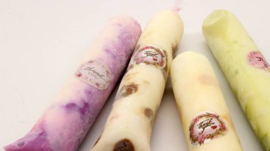 Beyaz arka planda izole edilmiş plastiğe sarılı pop buz çubuğu