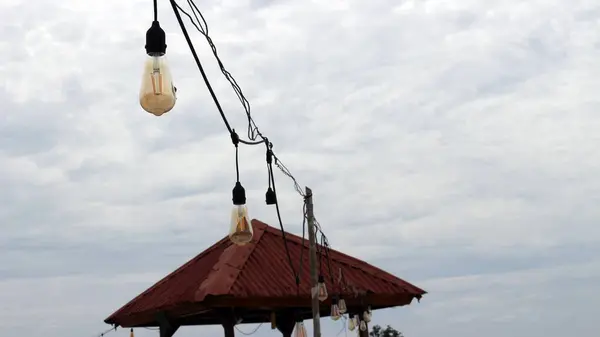 Açık havada asılı duran ampuller ve parlak bulutlar