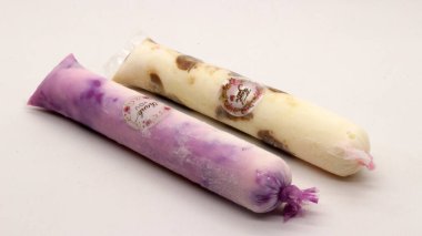 Beyaz arka planda izole edilmiş plastiğe sarılı pop buz çubuğu