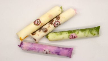 Beyaz arka planda izole edilmiş plastiğe sarılı pop buz çubuğu