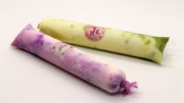 Beyaz arka planda izole edilmiş plastiğe sarılı pop buz çubuğu