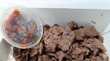 Pişmiş ve paketlenmiş et parçaları, servis edilmeye ve yenmeye hazır.