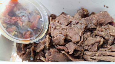 Pişmiş ve paketlenmiş et parçaları, servis edilmeye ve yenmeye hazır.