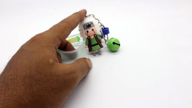 Adamın elinde naruto anahtarlığı beyaz arka planda izole edilmiş.