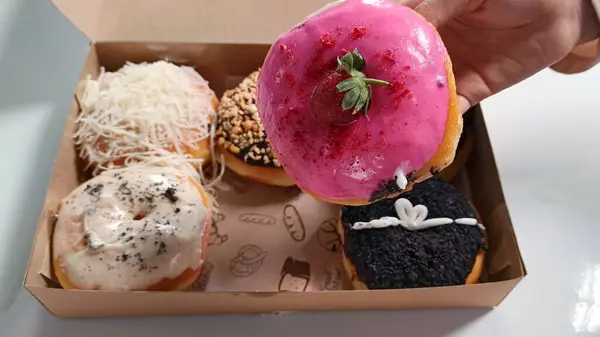 Kutudaki çeşitli tatlardaki lezzetli çörekleri yakından izle.