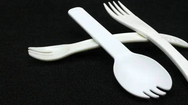 Siyah arkaplanda beyaz plastik çatal