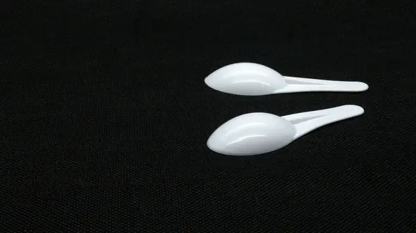 Şurup kaşığı siyah arkaplanda izole edilmiş.