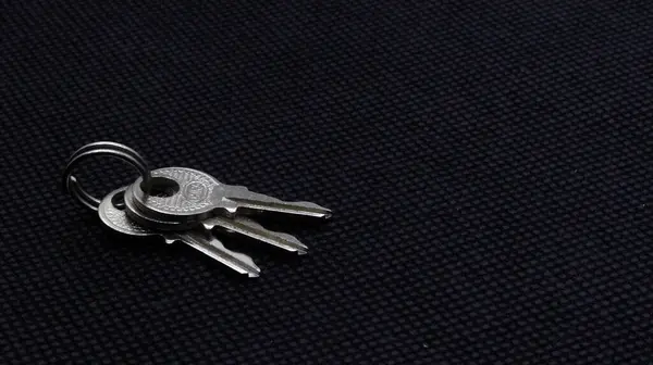 Siyah arkaplanda izole edilmiş küçük gümüş metal anahtar