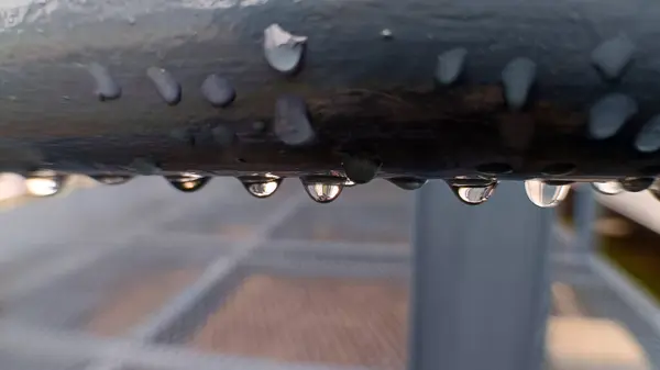 Metal bir korkuluktaki yağmur damlasını kapat