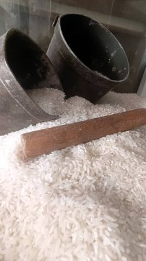 Ahırda iki metal ölçü kabıyla beyaz pirinç satılıyor.