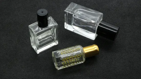 Siyah arka planda izole edilmiş cam parfüm şişesi