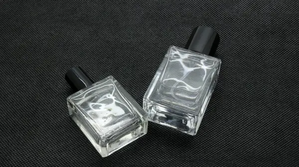 Siyah arka planda izole edilmiş cam parfüm şişesi