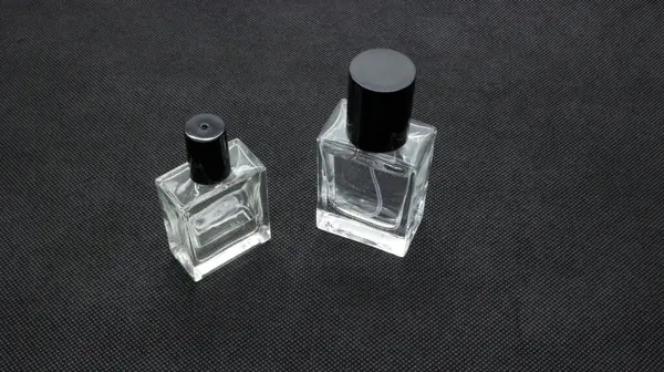 Siyah arka planda izole edilmiş cam parfüm şişesi