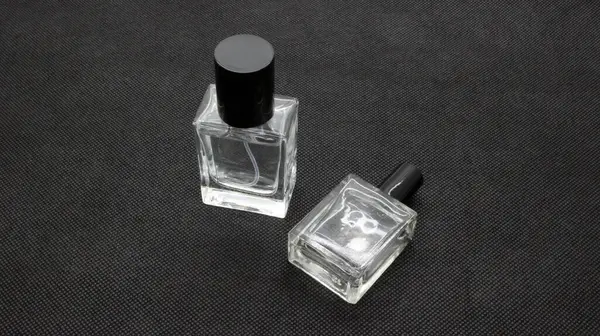 Siyah arka planda izole edilmiş cam parfüm şişesi