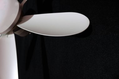 LED ışığı ve uzaktan kumandalı tavan vantilatörü siyah arkaplanda izole edilmiş.