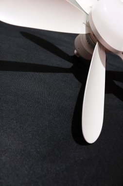 LED ışığı ve uzaktan kumandalı tavan vantilatörü siyah arkaplanda izole edilmiş.