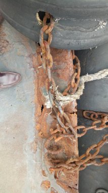 Eski paslı zincir eski lastikleri tutuyor