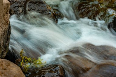close-up of the water flow of a mountain stream between the rocks with a silk effect