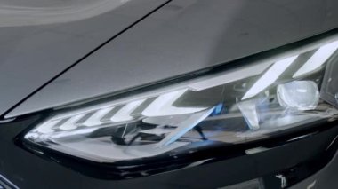 Işık sızıyor. LED optik mercekli modern bir arabanın farlarından kamera merceğine aydınlatma