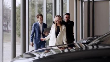 Afro-Amerikan araba danışmanı salonda yeni arabadan erkek müşteriye anahtarları sunuyor. Mutlu genç adam yeni bir araç alıyor. Satış ve iş konsepti.