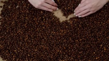 A woman's hand is stirring roasted coffee. enjoys the touch of the fragrant grains. Harvest coffee.