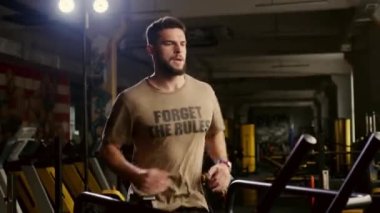 Fitness merkezinde egzersiz koşu bandı makinede Koşucu adam eğitim. Spor salonunda koşu makinesi fitness adam eğitim kardiyo egzersiz. Yakışıklı koşucu spor kulübü etrafında bakıyor
