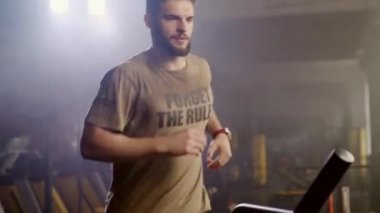 Fitness merkezinde egzersiz koşu bandı makinede Koşucu adam eğitim. Spor salonunda koşu makinesi fitness adam eğitim kardiyo egzersiz. Yakışıklı koşucu spor kulübü etrafında bakıyor