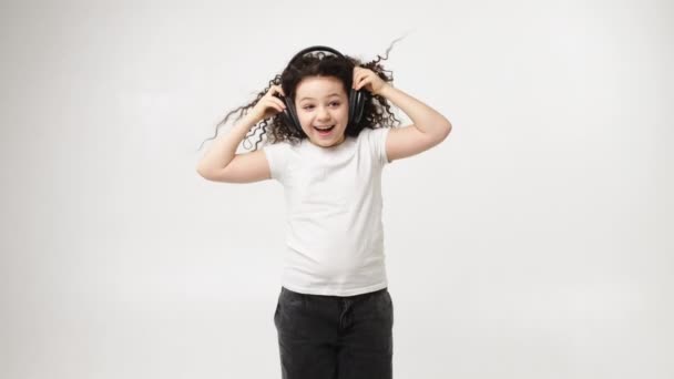 Little Charming Curly Girl Charming Smile Listens Music Wireless Headphones — ストック動画