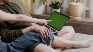 Mutlu genç çift internet alışveriş yapıyor ya da evde birlikte uygulamaları kullanarak yeni ev tasarımı planlama konuşma dizüstü bilgisayar ile oturup, gülümseyen erkek ve kadın web sitesinde online mal satın alma seçme tartışıyor