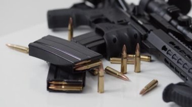 Siyah demirden modern ordu makineli tüfek ve fişekler, beyaz arka planda optik görüşe sahip askerler için küçük silahlar yatıyor. Yakın plan.
