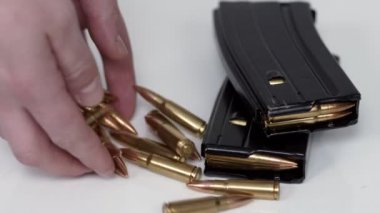 Siyah demirden modern ordu makineli tüfek ve fişekler, beyaz arka planda optik görüşe sahip askerler için küçük silahlar yatıyor. Yakın plan.