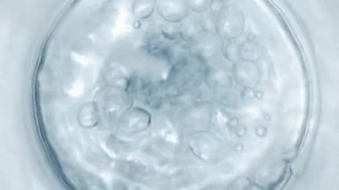 Pure Water Poured Into Glass closeup on light gray background. Super slow motion. Quenching thirst concept. Clear fresh drinking water filling glass close up