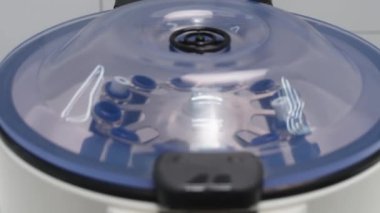 Cosmetologist extracting blood plasma using a centrifuge. The doctor takes out tubes with blood plasma.